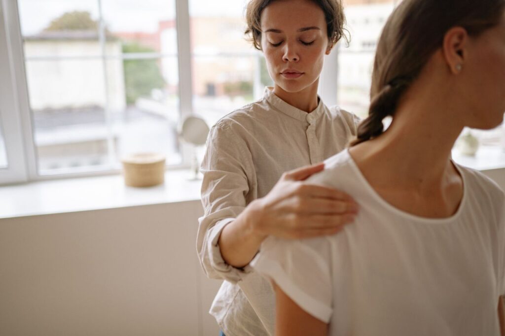 A physiotherapist provides treatment to a client in a bright, modern clinic setting.